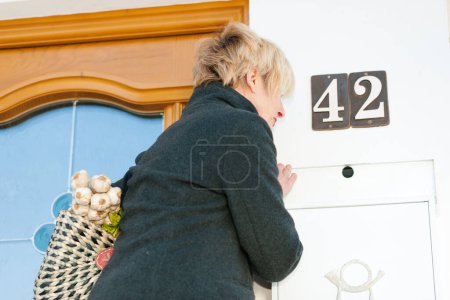 Photo for Woman with groceries checking mail - Royalty Free Image