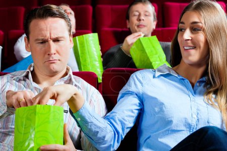 Téléchargez les photos : Couple au cinéma avec pop-corn - en image libre de droit