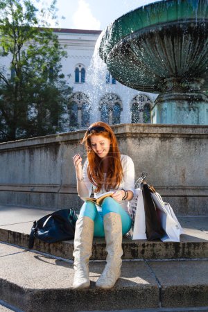 Photo for Woman sitting in front of fountain - Royalty Free Image