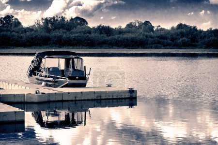 Téléchargez les photos : Petit bateau à la jetée sur la rivière
. - en image libre de droit