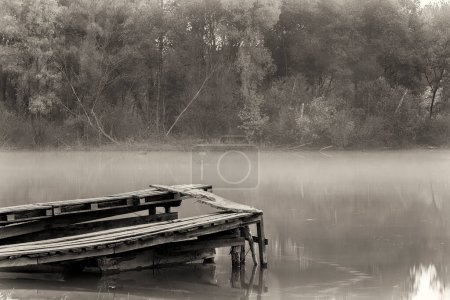 Foto de "Old ruined pier on the river on a foggy morning." - Imagen libre de derechos
