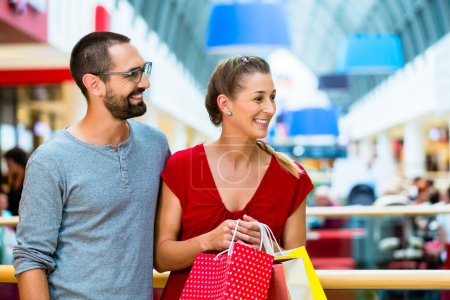 Téléchargez les photos : "Homme et femme dans le centre commercial avec des sacs
" - en image libre de droit