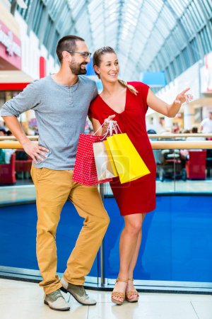 Photo for "Man and woman in shopping mall with bags" - Royalty Free Image