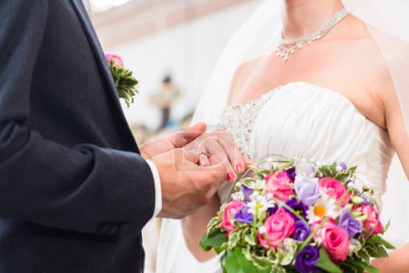 Téléchargez les photos : "Groom bague glissante sur le doigt de la mariée au mariage
" - en image libre de droit