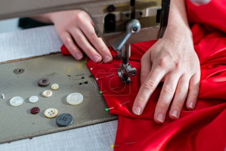 Foto de "Detalle de la mujer en la máquina de coser y botones" - Imagen libre de derechos