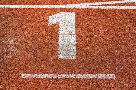 Téléchargez les photos : "Commencez numéro un sur la piste cinder de la piste de course d'athlétisme" - en image libre de droit