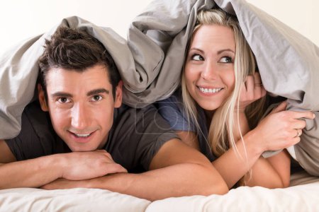 Photo for "Portrait of happy young couple in bed" - Royalty Free Image