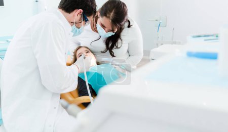 Photo for Dentist trearing child in his surgery - Royalty Free Image