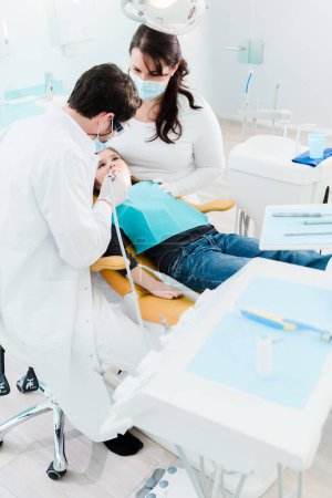 Photo for Dentist trearing child in his surgery - Royalty Free Image