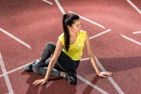 Photo for "Woman sprinter doing warm up exercise before sprint" - Royalty Free Image