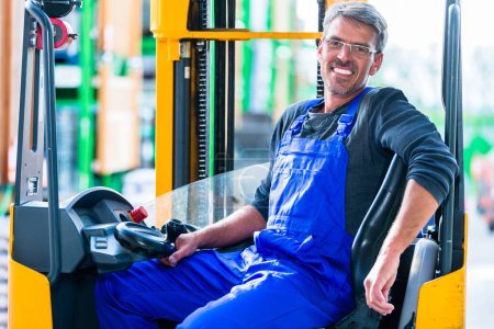 Photo for "Home improvement store clerk driving forklift" - Royalty Free Image
