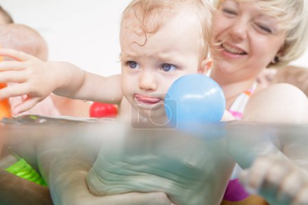 Téléchargez les photos : Maman et bébé s'amusent au cours de natation pour bébés - en image libre de droit