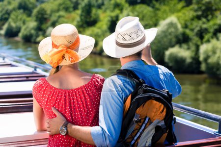 Photo for "Happy couple on river cruise wearing sun hats in summer" - Royalty Free Image