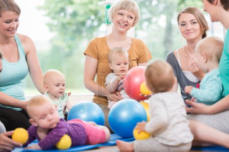 Photo for Young women in mother and child group playing with their baby kids - Royalty Free Image