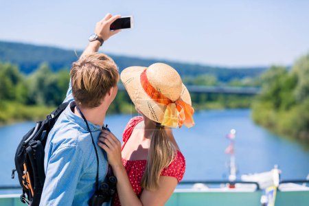 Photo for "Young couple on river cruise in summer taking selfie" - Royalty Free Image