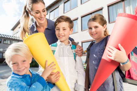 Photo for Woman and kids at enrolment day with school cones - Royalty Free Image