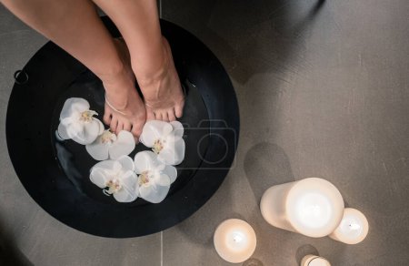 Foto de "Pies femeninos durante el lavado terapéutico asiático en el centro de belleza de lujo" - Imagen libre de derechos
