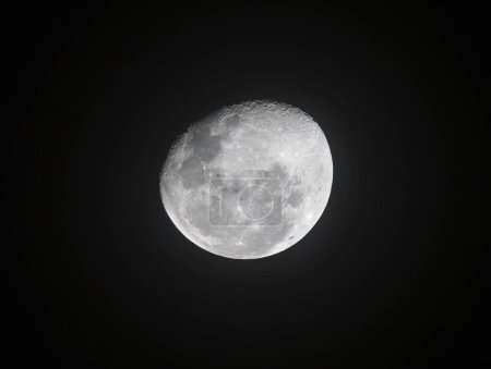 Photo for "Moon through telescope with visible craters and the sea of tranquility." - Royalty Free Image