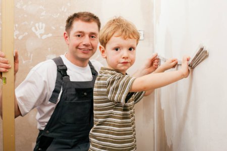 Photo for "Father and son measuring dry wall" - Royalty Free Image