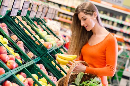 Téléchargez les photos : Femme achetant des fruits dans une épicerie ou un supermarché - en image libre de droit