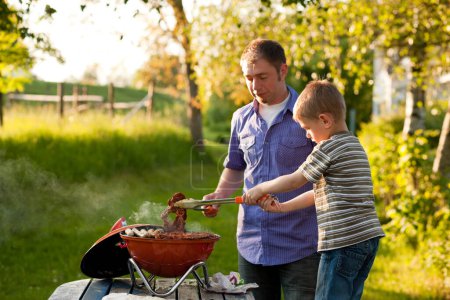 Téléchargez les photos : Famille ayant barbecue dans leur jardin - en image libre de droit