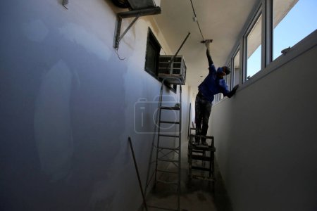 Foto de Pintor de pared trabajando dentro del edificio - Imagen libre de derechos