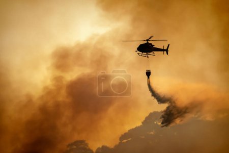 Foto de Helicóptero vertiendo agua en incendios forestales - Imagen libre de derechos