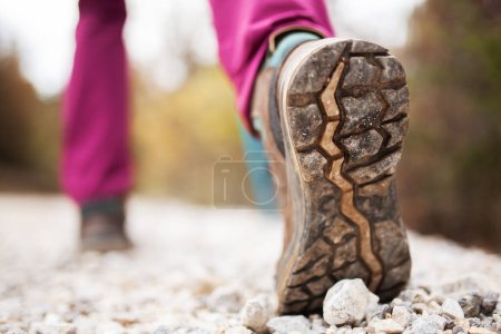 Foto de "Chica senderista en la naturaleza. Vista de ángulo bajo de zapato deportivo genérico y piernas en el camino de tierra de guijarros. Estilo de vida saludable fitness al aire libre." - Imagen libre de derechos