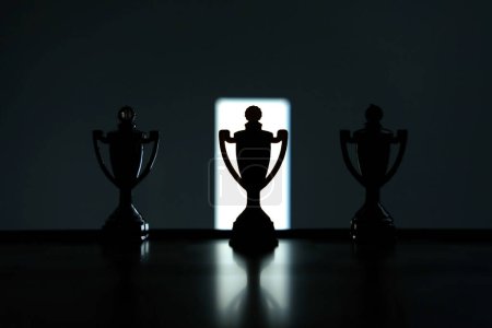 Téléchargez les photos : Stratégie d'entreprise photo conceptuelle Silhouette de trophées debout au milieu de la table de bureau - en image libre de droit