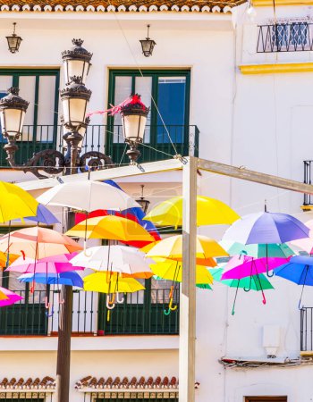 Téléchargez les photos : "Colourful umbrellas urban street decoration. Hanging colorful umbrellas over blue sky, tourist attraction" - en image libre de droit