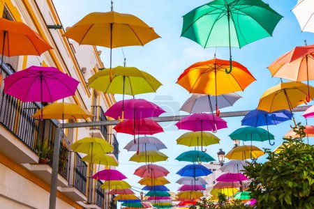 Téléchargez les photos : "Colourful umbrellas urban street decoration. Hanging colorful umbrellas over blue sky, tourist attraction" - en image libre de droit