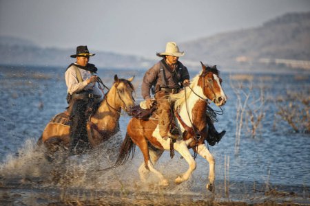 Téléchargez les photos : Cowboy riding horse against sunset - en image libre de droit