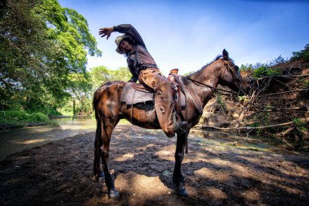 Foto de "cowboy riding horse against sunset	" - Imagen libre de derechos