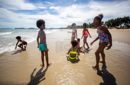 Foto de Niños jugando y divirtiéndose en la playa de arena cerca del mar - Imagen libre de derechos