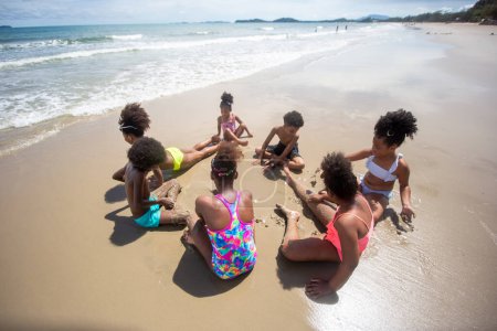 Foto de Niños jugando y divirtiéndose en la playa de arena cerca del mar - Imagen libre de derechos