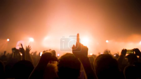 Foto de "Concert Music festival and Celebrate. Party People Rock Concert. Crowd Happy and Joyful and Applauding or Clapping. Celebration party festival happiness. Blurry night club. Concert Show with DJ Music festival EDM on Stage" - Imagen libre de derechos