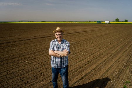 Téléchargez les photos : Agriculteur dans la vue sur le terrain - en image libre de droit