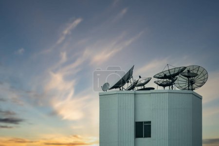 Téléchargez les photos : "antenne parabolique sur le dessus du bâtiment avec un beau ciel." - en image libre de droit