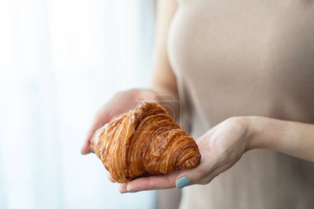 Photo for "Woman hand serving baked crispy croissants." - Royalty Free Image