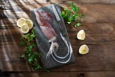 Téléchargez les photos : Fresh raw squid on wooden table - en image libre de droit