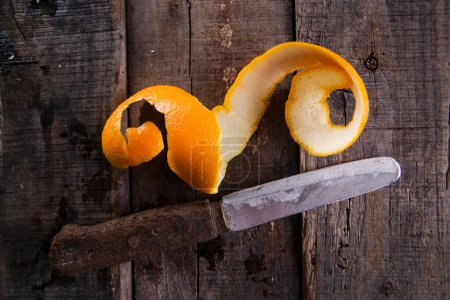 Foto de Vista superior de la cáscara de naranja y cuchillo vintage sobre fondo de madera - Imagen libre de derechos