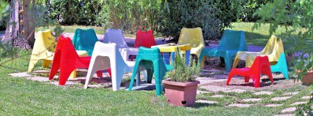 Téléchargez les photos : Chaises colorées et lumineuses dans le jardin - en image libre de droit