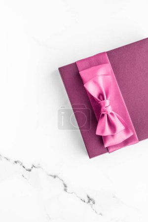 Téléchargez les photos : "Coffret cadeau rose avec noeud en soie sur fond de marbre, cadeau de douche bébé fille et cadeau de mode glamour pour la marque de beauté de luxe, conception d'art flatlay vacances" - en image libre de droit