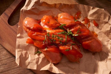 Foto de "Embutidos a la parrilla con salsa de tomate en una mesa de madera
" - Imagen libre de derechos