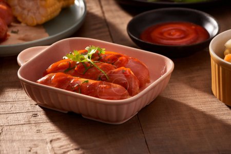 Téléchargez les photos : "Saucisses grillées avec ketchup sauce sur une table en bois
" - en image libre de droit