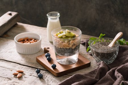 Photo for "Healthy breakfast - bowl of muesli, berries and fruit, nuts, kiwi, milk" - Royalty Free Image