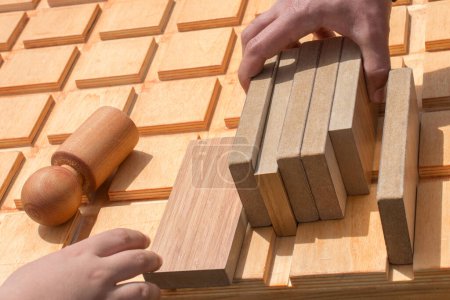 Téléchargez les photos : "Main tenant l'élément de puzzle en bois dans la main" - en image libre de droit