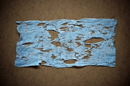 Foto de Un paño j azul muy utilizado con agujeros y lágrimas de uso - Imagen libre de derechos