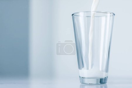 Photo for World Milk Day, pouring into glass on marble table - Royalty Free Image