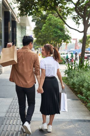 Téléchargez les photos : "Jeune couple heureux avec des sacs à provisions dans la ville
. " - en image libre de droit
